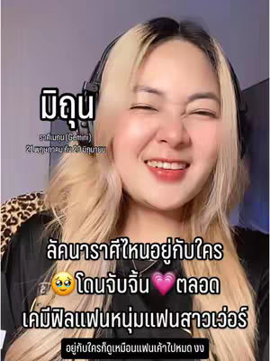 A close-up shot focuses on a smiling woman with long blonde hair, wearing headphones. Text overlays include a zodiac sign, text in Thai, and additional emojis.