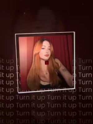 The cover image is a selfie-style shot framed within a white border, the image contains a young woman with long auburn hair, and a black top, who is looking at the camera, and has a red square graphic over her neck. The background appears to be a dark red or maroon. The words 'Turn it up' are repeated in a faded grey gradient over the background.