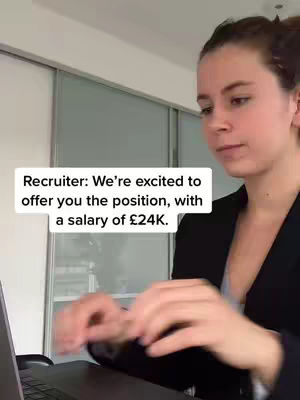 A young woman is sitting at a desk, facing towards the right. She has her hair pulled back. A text overlay is on the image.