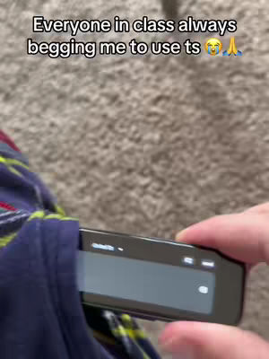 The cover image shows a person's hand holding a black electronic device, possibly a scanner or reader, partially inserted into a blue pocket. The background is a blurry, neutral color. The text overlay says, 'Everyone in class always begging me to use ts ππ'.