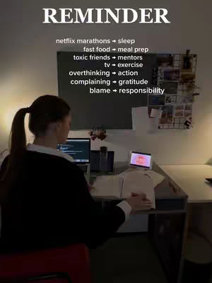 A person is sitting at a desk with a laptop and an additional screen. The person is viewed from the back, and there is a list of self-improvement reminders above them.