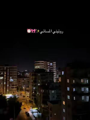 A night cityscape with buildings and lights. The sky is dark, with the overlayed text at the top. Buildings are lit with various colors.