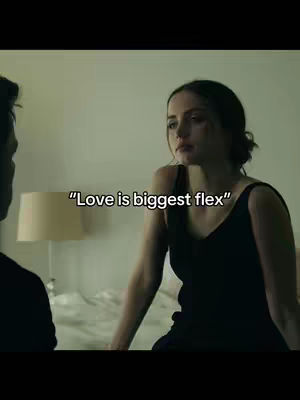 An interior shot featuring a woman and a man, with the woman seated and the man partially visible with his back to the camera. The woman is the focal point, set against a blurred background that hints at a bedroom scene. The overlay text gives a caption on top of the image.