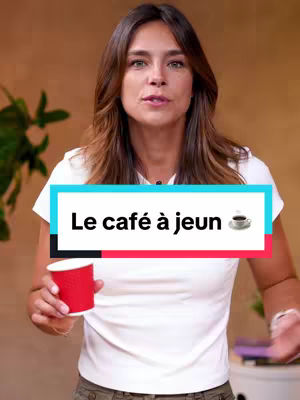 A woman in a white t-shirt stands in front of a blurred background, holding a red coffee cup. A text overlay reads "Le café à jeun". The overall composition is a medium shot, with the woman centrally positioned.