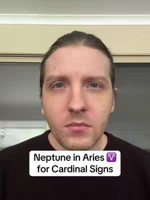 A cover image featuring a man’s face filling most of the frame, with a neutral expression and a casual black shirt. A text overlay at the bottom reads 'Neptune in Aries for Cardinal Signs,' with a purple Neptune symbol. The background is a simple, out-of-focus indoor scene, with the man's hair pulled back.