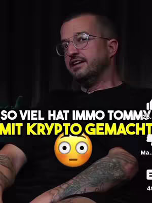 A medium shot captures a man with glasses, a beard, and tattoos on his arm, speaking. Bold, yellow text overlays the image, along with a surprised emoji.