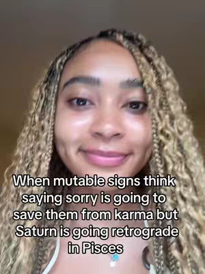 A selfie-style shot featuring a young woman with dark skin and long, braided hair. The woman looks directly at the camera with a slight smile, and a text overlay is present at the bottom of the image, providing context. The neutral background is blurred out.