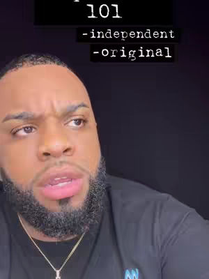A close-up shot of a Black man with a beard, looking up with a questioning expression.  Text overlayed on the top is in white, and reads 'Aquarius 101' and below that '-independent -original'. The man wears a black shirt and a gold chain.