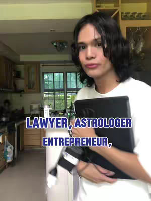 A person standing in a kitchen setting. The image is dominated by a person holding a black object, next to a sign with overlaid text.