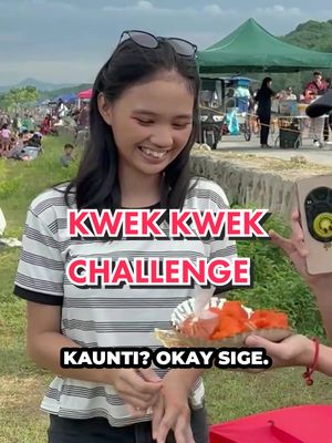 A young woman smiles in front of a blurred outdoor setting, wearing sunglasses atop her head. Overlaid text reads "KWEK KWEK CHALLENGE" in bold, colorful lettering, and a caption below asks "KAUNTI? OKAY SIGE." A platter of food is offered towards the creator from off-screen, emphasizing a challenge or interaction.