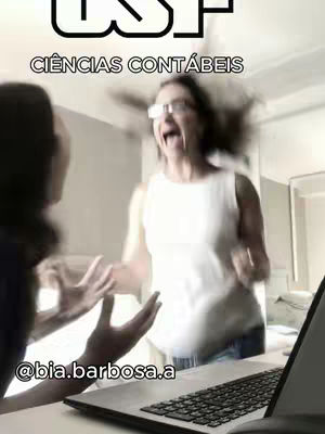 The image captures a moment of explosive excitement. In the foreground, a laptop sits open, hinting at the context of the video. The background is slightly blurred, but the focal point is a woman with glasses, her mouth wide open in an expression of shock or elation, with her hair seemingly blown backward, suggesting movement or strong emotion. To the left, partially visible, is another person reacting with their hands up.