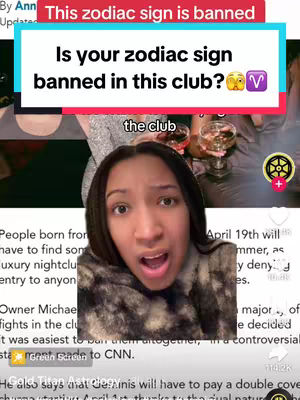 A selfie-style video cover shot featuring a young woman with a surprised expression. She has dark hair and is centered in the frame. Overlayed text in a red banner reads 'This zodiac sign is banned'. A question 'Is your zodiac sign banned in this club? 👀' is in a teal rectangle overlayed in the image. The background behind the woman is blurred, but appears to be an upscale club setting with people and drinks. Text about a club banning certain zodiac signs is present, along with the Aries symbol.