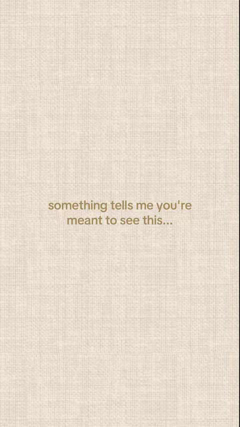 The image is a full-frame shot with a light tan, textured backdrop, resembling fabric or canvas. Centered, in slightly darker tan text, is the phrase: 'something tells me you're meant to see this...'. The composition is minimal, with the text being the primary focus, emphasizing the message presented.