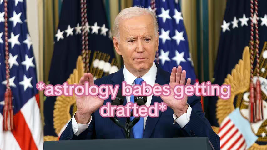A still image of Joe Biden at a podium, clad in a suit and tie, with his hands raised and palms facing forward. He is centered in the frame, with multiple American flags behind him. The foreground includes a superimposed text overlay.