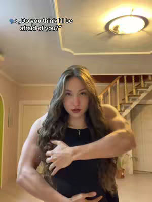 The cover image shows a woman in a black top posing in a room with a warm color palette. The woman has long wavy hair and appears muscular. Text overlay suggests a thematic question.
