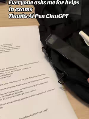 The image shows a black pen angled over an open book on a white surface. Text overlays read, "Everyone asks me for helps in exams Thanks Ai Pen ChatGPT". A black bag is partially visible on the right side of the image.