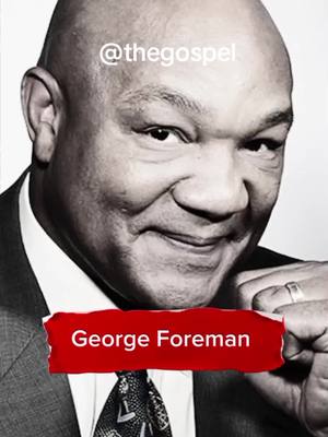 A black and white image featuring George Foreman, a bald Black man, smiling. He wears a suit and tie. A red banner with "George Foreman" in white text overlays the image.