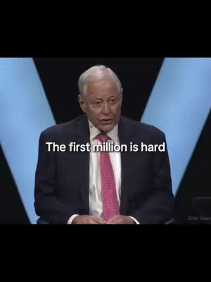 A man in a suit and tie is speaking in front of a blurred background with a “V” shape. The overlaying text is white text explaining the topic of the video.