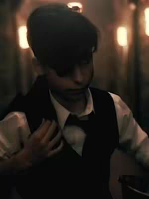 The cover image features a man in a classic, semi-formal outfit with a dark cap. He wears a white shirt beneath a black vest. There is a dark tie, and the person has a hand on their chest. The background is blurred with warm lighting.