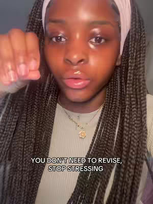 A close-up shot of a young woman with a serious expression, facing the camera. She has dark braids, a white headband, and is wearing a simple top. Text overlayed at the bottom of the screen reads, "YOU DON'T NEED TO REVISE, STOP STRESSING."