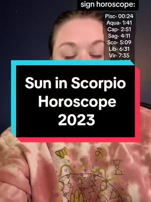 A woman's face is framed in an image, closed eyes and a text overlay in front. The text says, 'Sun in Scorpio Horoscope 2023' on a black rectangle with a blue border. The woman has light skin and is wearing a tie-dye pink shirt. Additionally, there is a list of zodiac sign times located in the upper right corner.