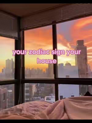 The image shows a view through a large window at dusk or dawn, with a pink and orange sky visible. The window frames a city skyline and a bed is close to the window. Text overlay in pink.