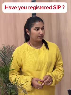 A woman wearing a yellow sweater is positioned in front of a light-colored background. Above her head is a white rectangular text overlay with the question, "Have you registered SIP ? " A few plants are visible on the left side, adding a touch of green to the scene.