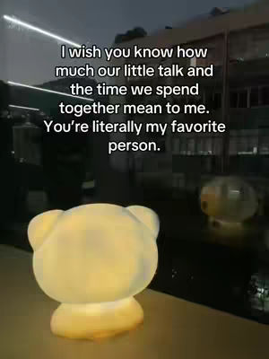 The cover image shows a dimly-lit scene, likely outdoors at nighttime, with a soft glow from a bear-shaped lamp in the foreground. Text overlays at the top reads "I wish you know how much our little talk and the time we spend together mean to me. You're literally my favorite person."