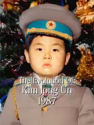 A young boy wearing a military-style uniform and hat poses for a photo, framed against a Christmas tree. Text overlayed reads 'The Evolution Of: Kim Jong Un 1987'.