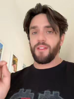 A man with dark hair and a beard is the central focus, pointing with his right index finger. The background includes a light-colored wall and what appears to be artwork. The image is lit with soft, natural light. Below the man, there's a text overlay in a red color that reads 'MISS THIS ONE'