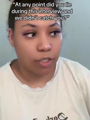 A close-up shot features a woman with dark hair pulled back, wearing a white t-shirt. She has makeup on, including purple eyeshadow. Above her, text overlays the image in a white, sans-serif font.
