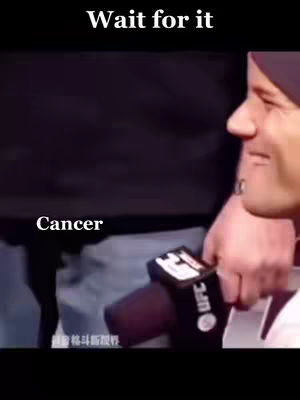 The cover image features a man, seen from the side, with a portion of his face visible, holding a microphone. Text overlays include "Wait for it" at the top and "Cancer" in the lower left.
