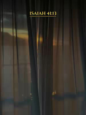 The image displays a view through semi-transparent curtains. Vertical lines of the fabric create a striped pattern. Behind the curtains, a golden light suggests a sunrise or sunset. Above the curtains, written in a golden font, is the text "ISAIAH 41:13".