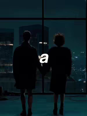 Two people stand in front of a large window, looking out at a city at night. The foreground silhouettes are of a person on the left and a person on the right, both wearing dark clothing. Between them, a stylized white letter 'a' is overlaid on the image. The background showcases city lights, giving a sense of depth and scale.