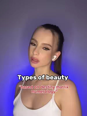 A young woman with long brown hair and visible makeup, wearing a white top, is the focal point. She has airpods in her ears and is posing with a light blue background. Text overlays read 'Types of beauty' and '*based on destiny matrix numerology*'.