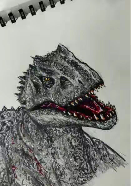 A detailed, close-up colored pencil drawing of an Indominus Rex head is shown against a white background. The dinosaur's head is rendered in shades of gray and white, with a rugged, textured appearance emphasizing its large size. The Indominus Rex's mouth is open, revealing a red interior and sharp, white teeth. The background and top portion of the image are white, with part of a spiral notebook visible at the top holding the paper in place. The artwork itself is positioned towards the bottom, with a focus on the dinosaur's head and neck.