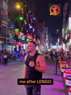 A man stands on a city street at night. The image has a warm color palette with neon signs and lights. There is a text overlay at the bottom.