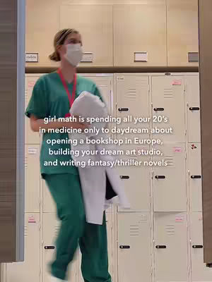 A woman in medical scrubs and a mask walks in a hallway, holding a white coat. The background consists of lockers.