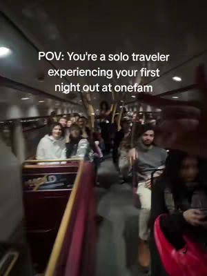 The video shows people in a bus or similar enclosed vehicle, likely traveling at night. There's a POV shot of the interior, with blurred faces of people sitting in rows. Dim lighting emphasizes the night setting and captures the interior of a bus-like environment.