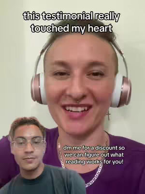 The image is a selfie-style video with the creator in the center, wearing headphones. A smaller inset shows another person in the lower-left corner. Text overlays the video, offering a discount on readings for those with Taurus placements, and another text reads 'this testimonial really touched my heart'. The background appears to be a plain wall. The overall color scheme is natural with a focus on warm tones.