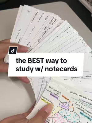 A hand holds up a fan of flashcards, the cards are blank with handwritten notes. A text box overlays the image, saying 'the BEST way to study w/ notecards'. The background is a neutral surface.