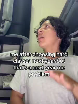 The cover image features a young man in a white t-shirt looking up and to the right, seemingly mid-sentence. Text overlayed on the image reads, 'me after choosing hard classes next year but that's a next year me problem'. The background is blurred, with visible elements like a dark object above the man's head and a hint of a shelving unit on the left.