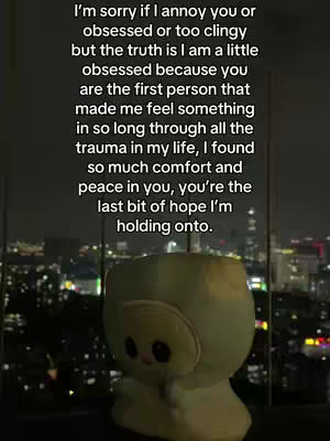 The image shows a nighttime cityscape with tall buildings and lights in the background. A soft, plush toy with a light green or blue color is in the foreground, obscuring part of the view. The text is overlaid on the image, using a white font.