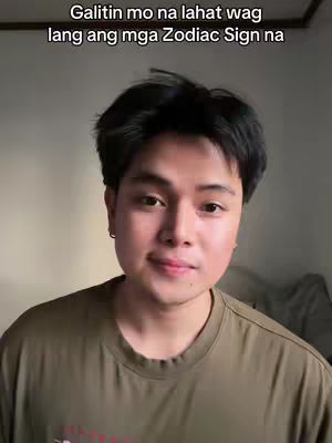 A young man with dark hair and a neutral expression stands in front of a plain background. He's wearing a dark olive-green t-shirt and appears to be indoors, possibly in a home setting. Above him, there's overlaid text.