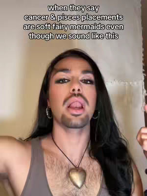 The image features a person with heavy makeup and long hair, sticking out their tongue. Text overlayed at the top states, "when they say cancer & pisces placements are soft fairy mermaids even though we sound like this."