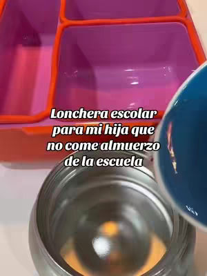 The image shows a lunchbox and a container with blue liquid being poured into a steel container. The lunchbox is an open, empty, multi-compartment plastic lunchbox. The text overlay is located at the bottom left of the image.