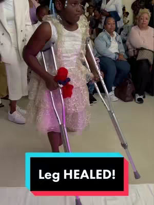 A young girl in a white and gold dress, holding crutches, standing in a brightly lit room with a crowd of people in the background. A highlighted rectangular box at the bottom of the image reads "Leg HEALED!"