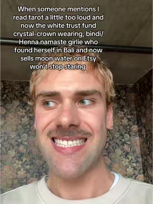 The cover image features a close-up of a man with short, styled blonde hair, a well-groomed mustache, and fair skin. He is wearing a light-colored, crew-neck sweater and has a slight smile, revealing his upper teeth. The background is a patterned wall. The composition is a centered close-up, with the man positioned in the middle, creating a sense of immediacy.