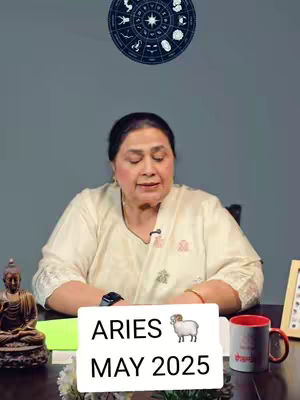 A woman sits at a table with a whiteboard in front of her displaying text. Behind her is a zodiac wheel, and a statue of Buddha sits on the table.