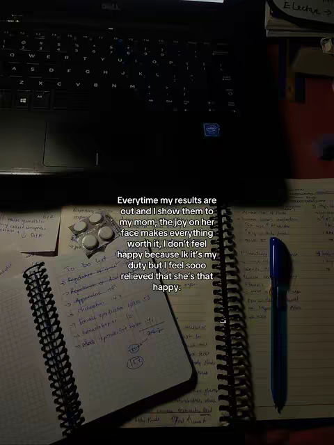 The cover image shows a close-up shot of a laptop keyboard in the upper-left, with a desk covered in items in the foreground. There's a notebook, a pen, a sticky note with writing, and some pills. The general color scheme is warm, with yellow and brown tones, giving a cozy feel. Text across the bottom of the image describes a student's appreciation for their mother.